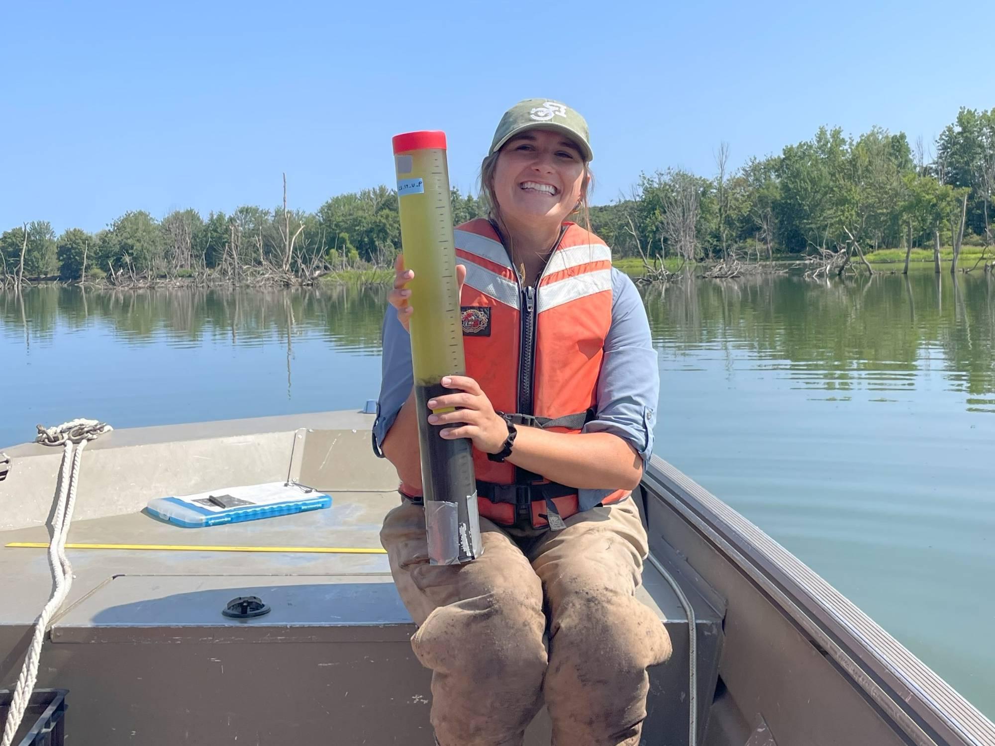 Kate Lucas holds a sediment core.